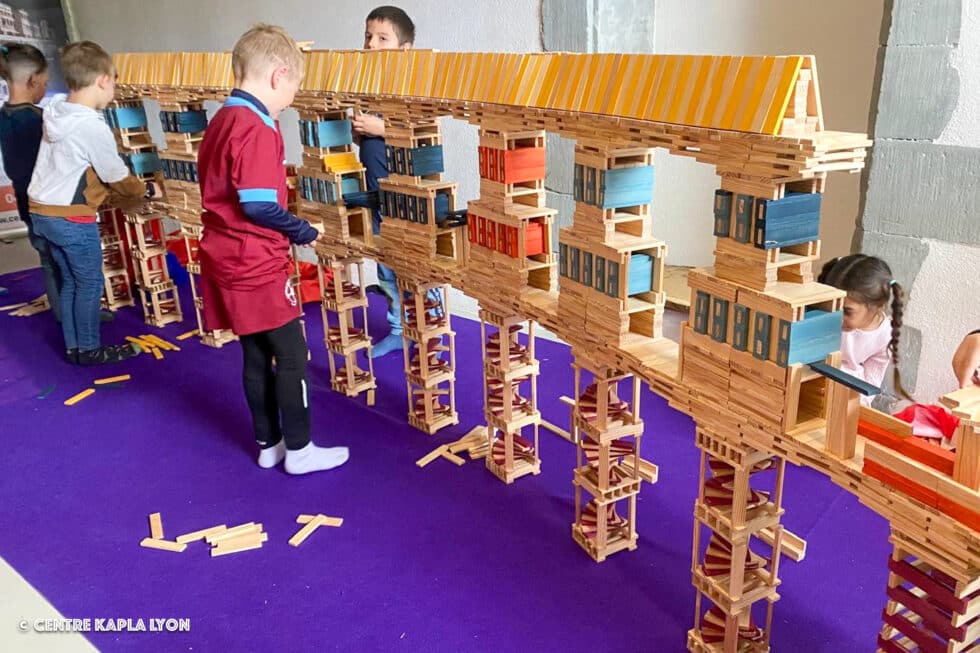 Des enfants construisent ensemble un montage monumental en planchettes Kapla avec le Centre Kapla Lyon